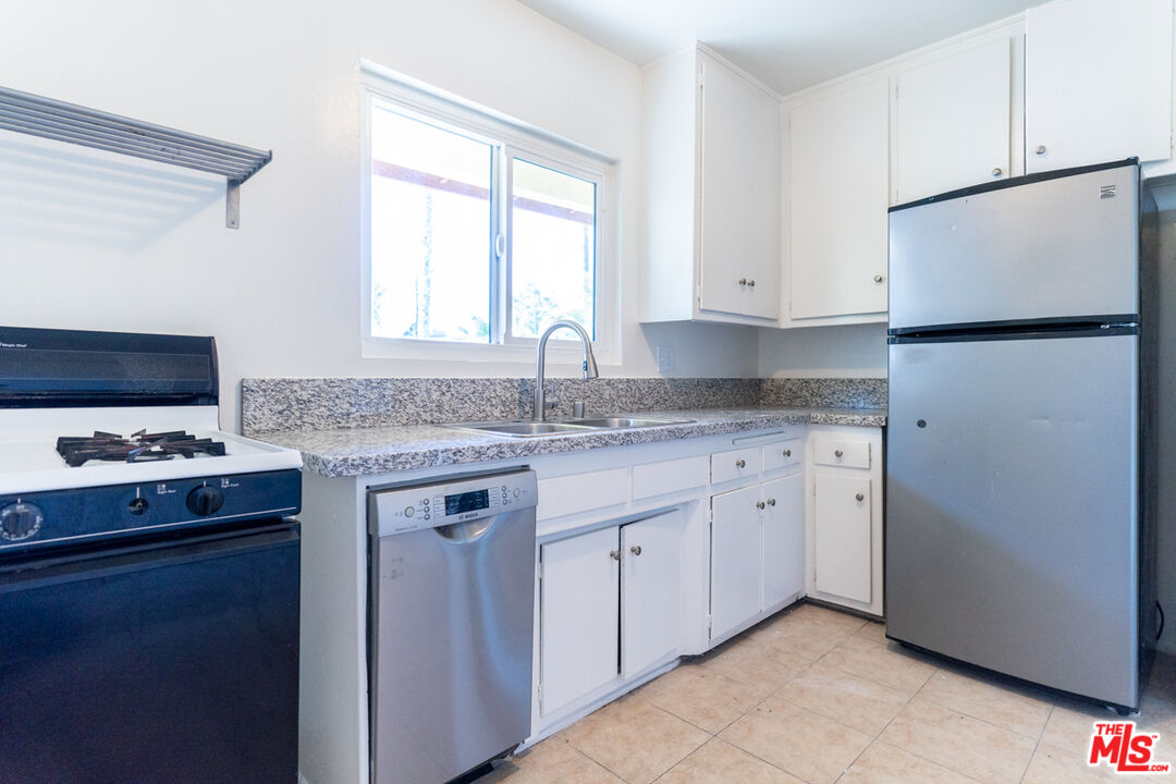 826 Hyperion Avenue Los Angeles, CA 90029 - Photo 18 of 25 a kitchen with granite countertop a sink stove and refrigerator