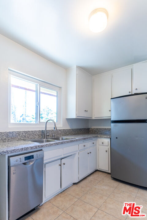 826 Hyperion Avenue Los Angeles, CA 90029 - Photo 19 of 25 a kitchen with granite countertop white cabinets and white appliances