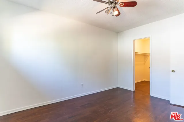 a view of a room with wooden floor and a ceiling fan