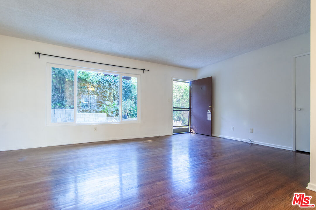 826 Hyperion Avenue Los Angeles, CA 90029 - Photo 4 of 25 a view of empty room with window and wooden floor