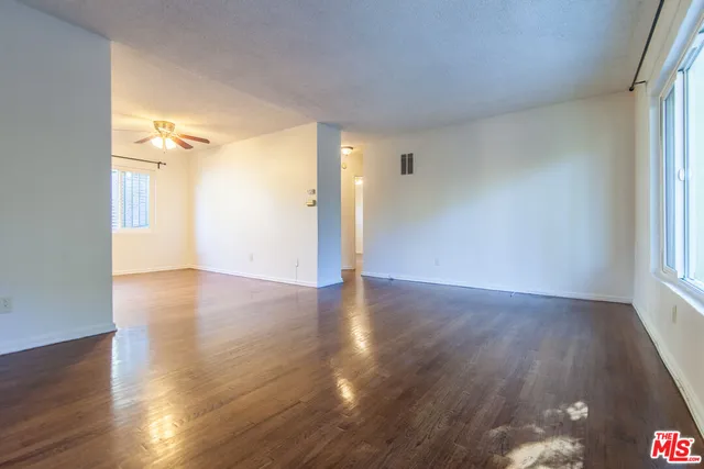 a view of a room with wooden floor and a window