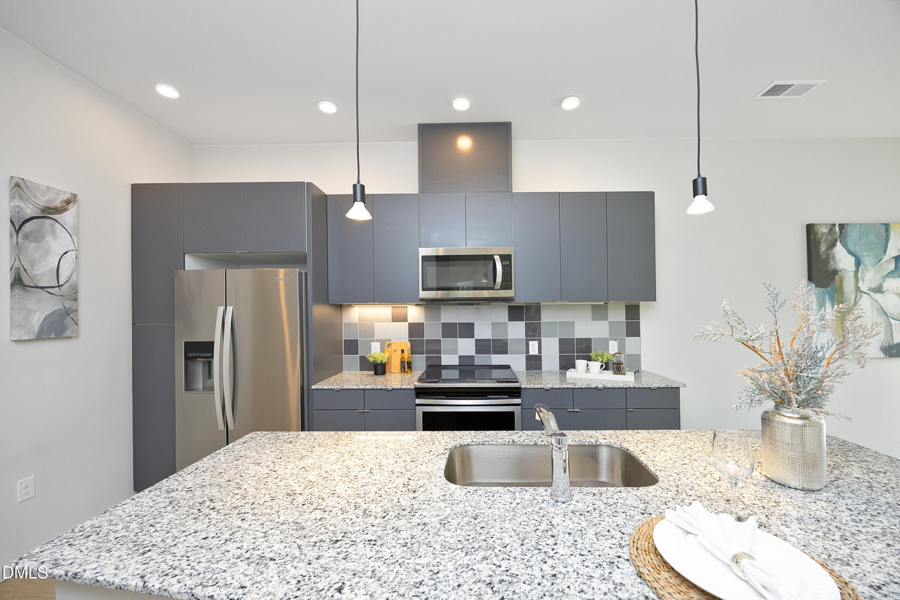600 South Duke Street, Unit 26 Durham, NC 27701 - Photo 7 of 35 a kitchen with stainless steel appliances granite countertop a refrigerator a sink a stove a microwave and island