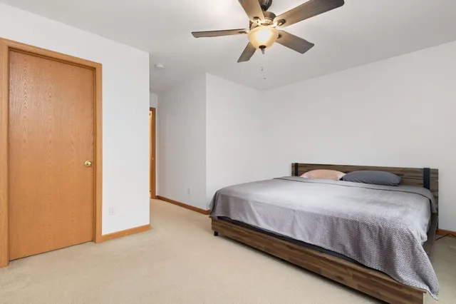 a bedroom with a bed and a ceiling fan