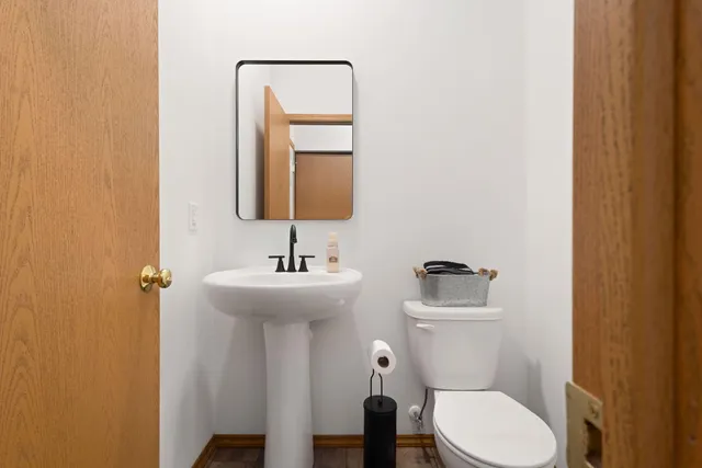 a bathroom with a toilet sink and mirror