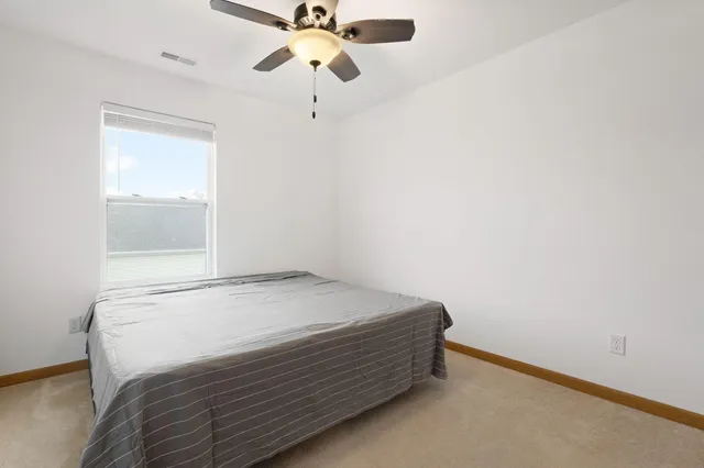 a bedroom with a bed and a chandelier fan