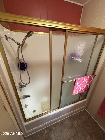 a bathroom with a glass shower door and a window