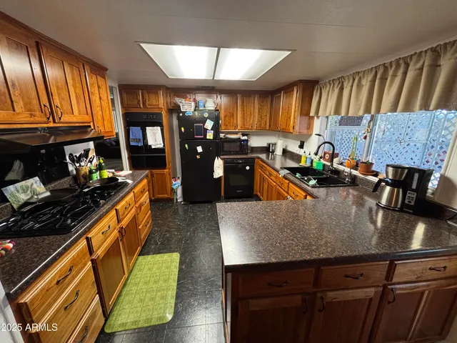a kitchen with stainless steel appliances granite countertop a refrigerator a stove and a sink dishwasher
