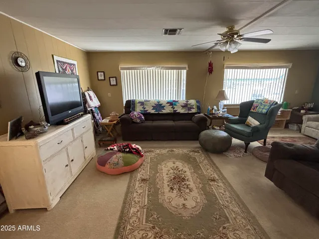 a living room with furniture a flat screen tv and a window