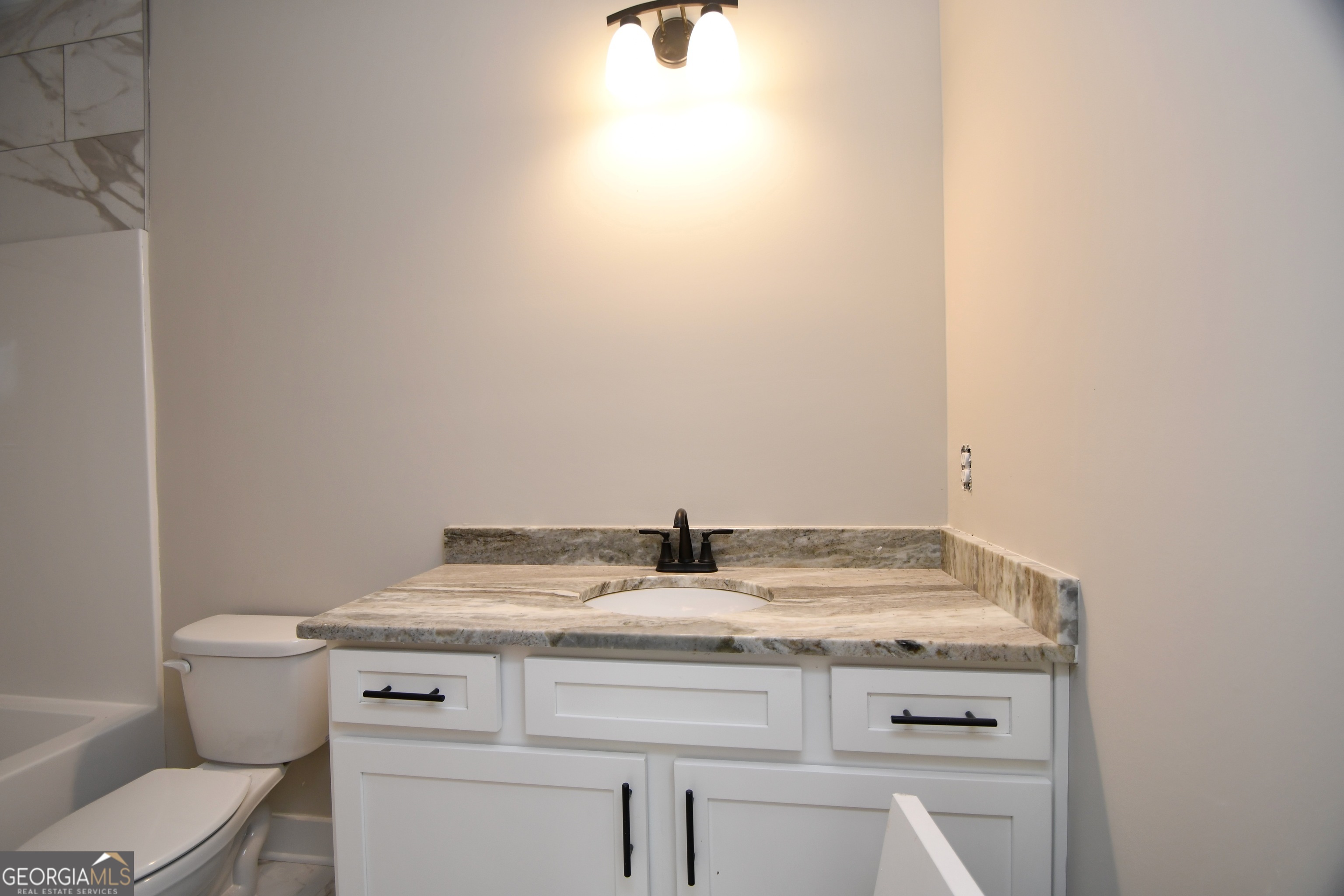 1021 Pointe Street South Tignall, GA 30668 - Photo 15 of 24 a bathroom with a granite countertop toilet and sink