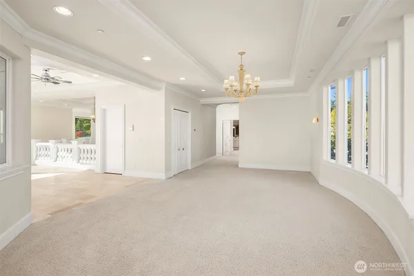 a view of an empty room with chandelier and window