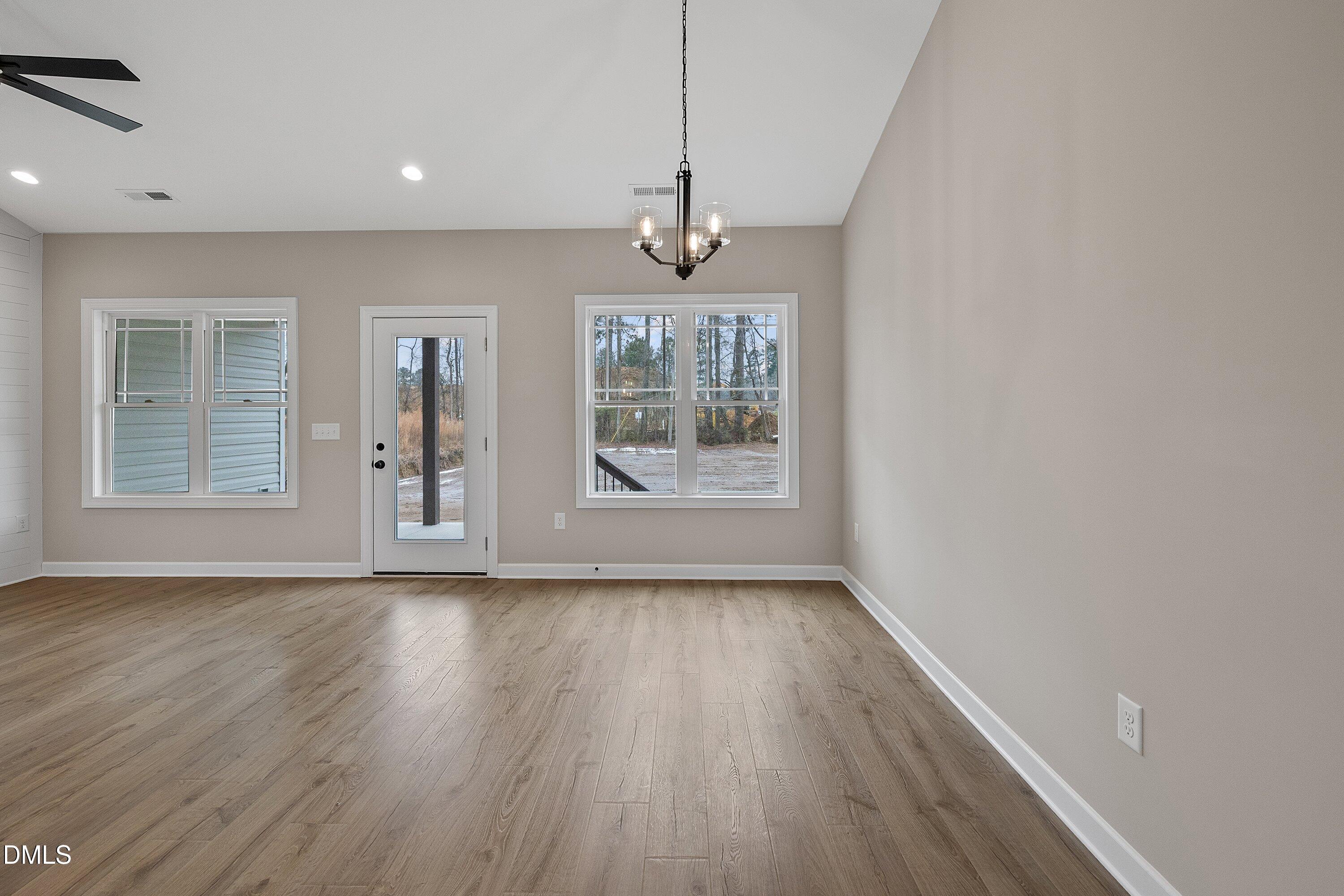 922 Micro Road West Selma, NC 27576 - Photo 17 of 36 an empty room with wooden floor windows and cabinet