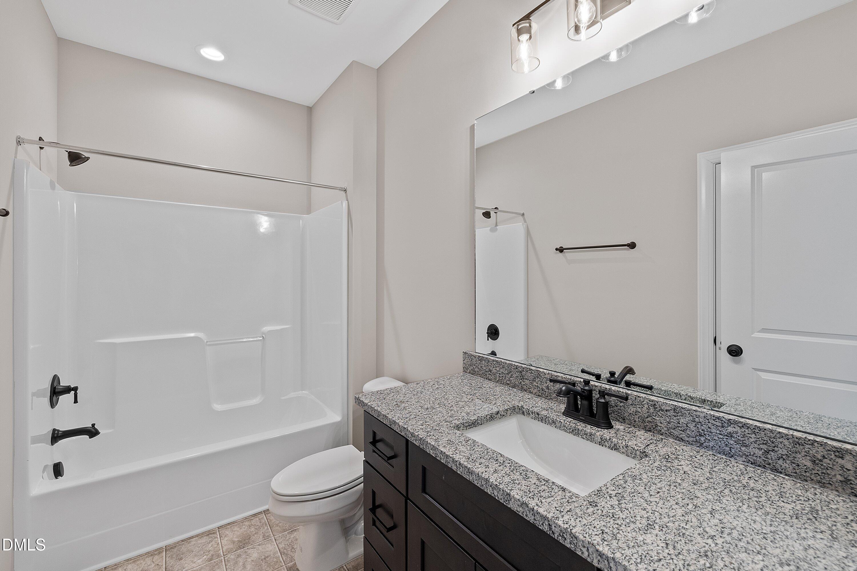 922 Micro Road West Selma, NC 27576 - Photo 28 of 36 a bathroom with a granite countertop sink toilet mirror and shower