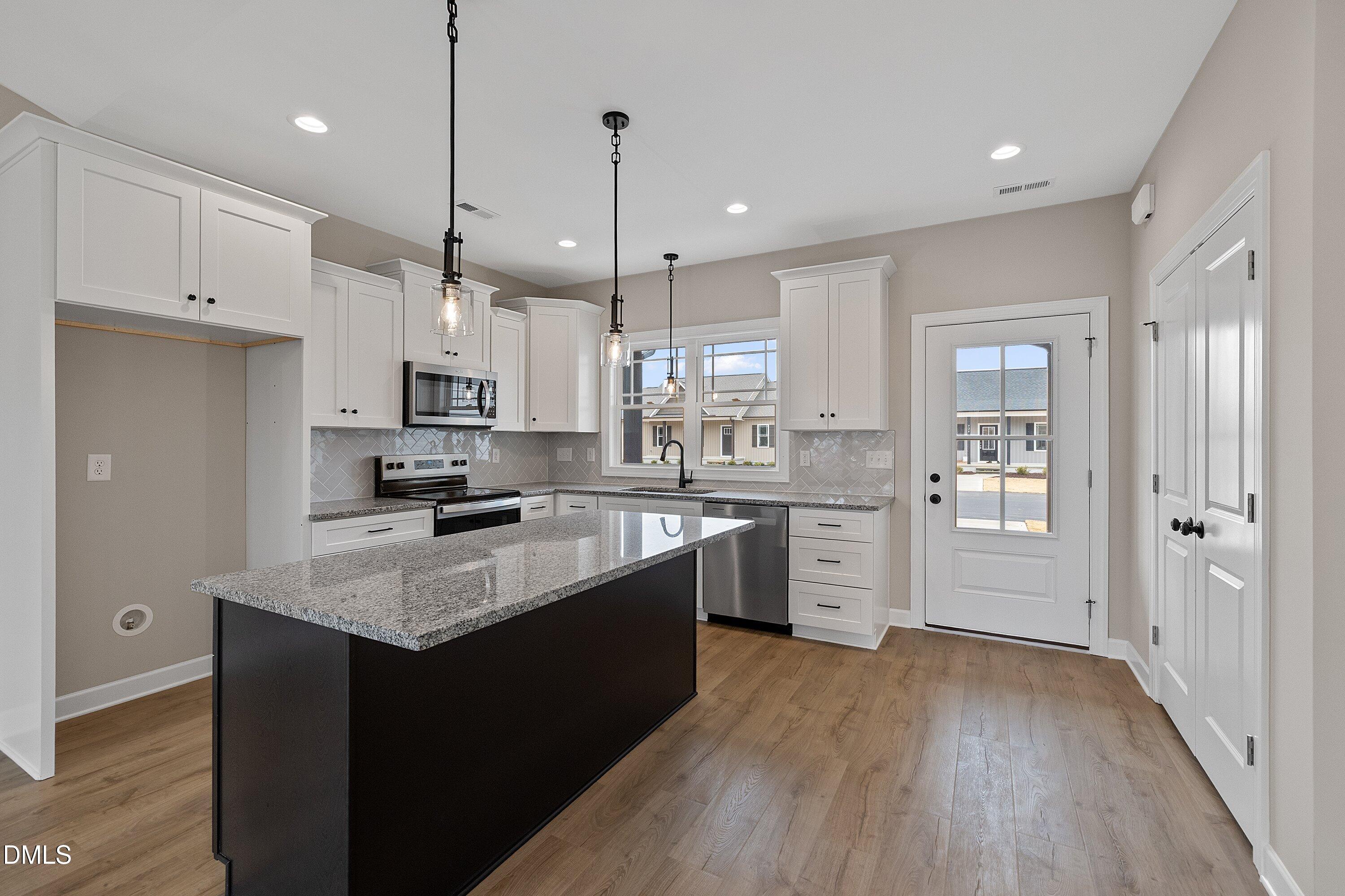 922 Micro Road West Selma, NC 27576 - Photo 5 of 36 a kitchen with stainless steel appliances granite countertop a sink stove and refrigerator