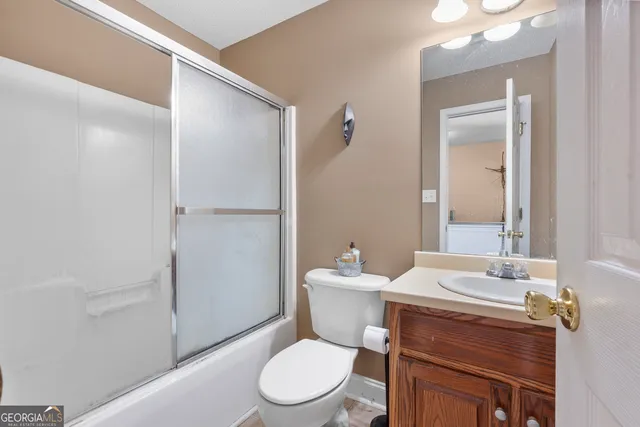 a bathroom with a toilet a sink and mirror