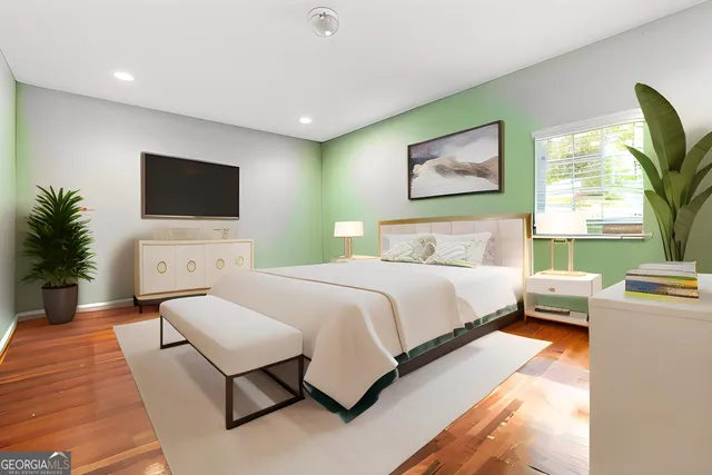 a spacious bedroom with a bed and a flat screen tv