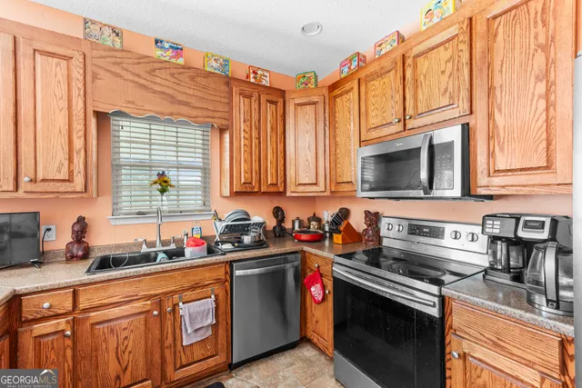 a kitchen with stainless steel appliances granite countertop a sink stove and microwave