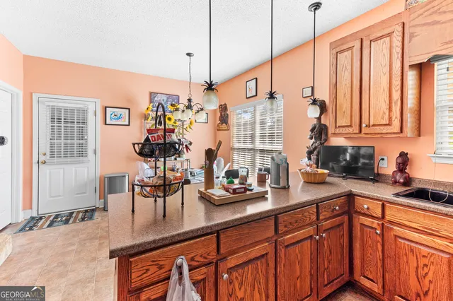 a kitchen with stainless steel appliances granite countertop a sink a stove and a wooden cabinets