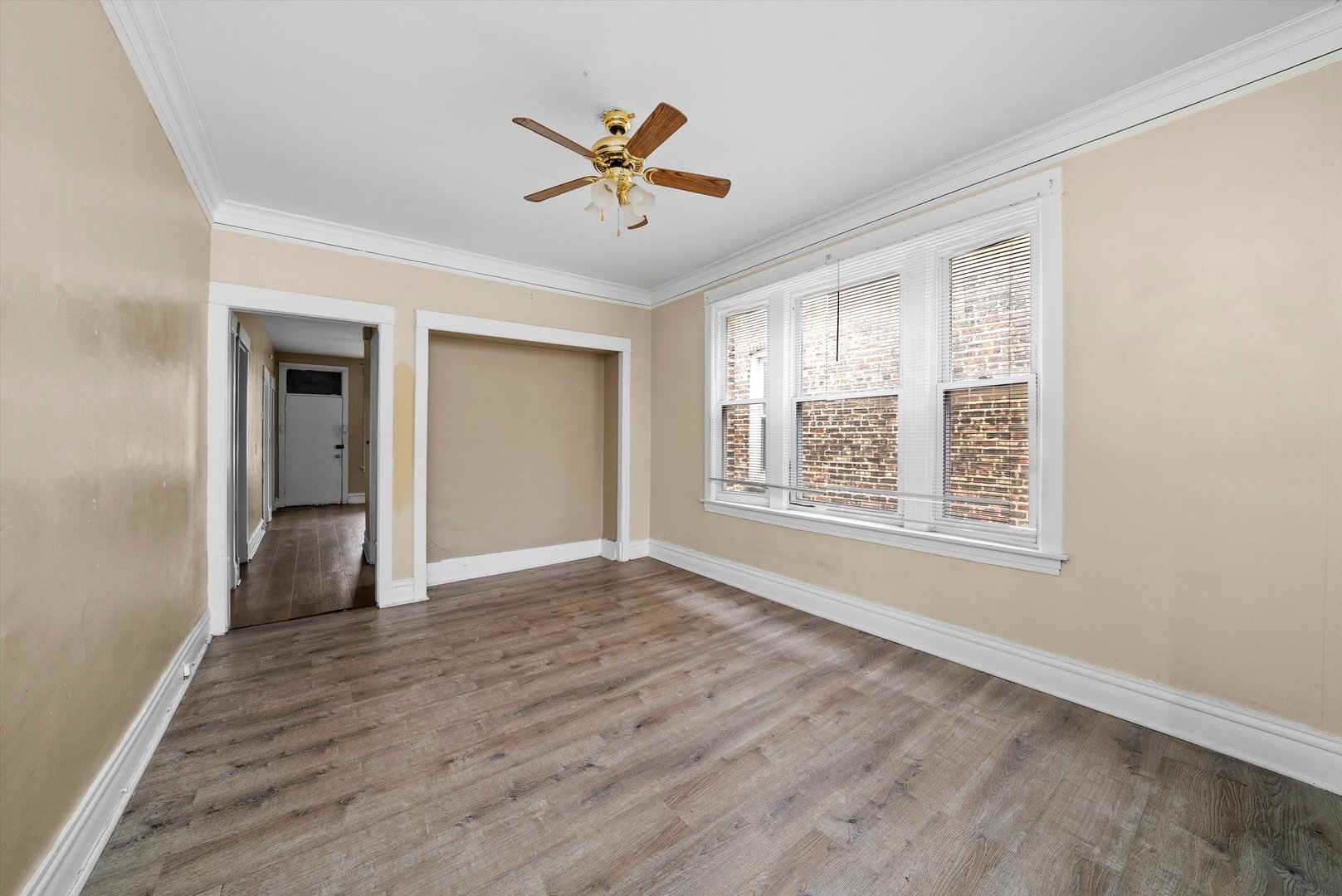 4318 West Cermak Road Chicago, IL 60623 - Photo 3 of 17 a view of an empty room with a window and wooden floor