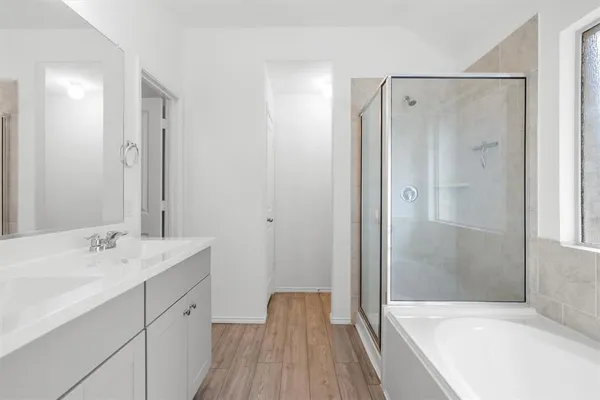 a bathroom with a tub shower vanity and a sink