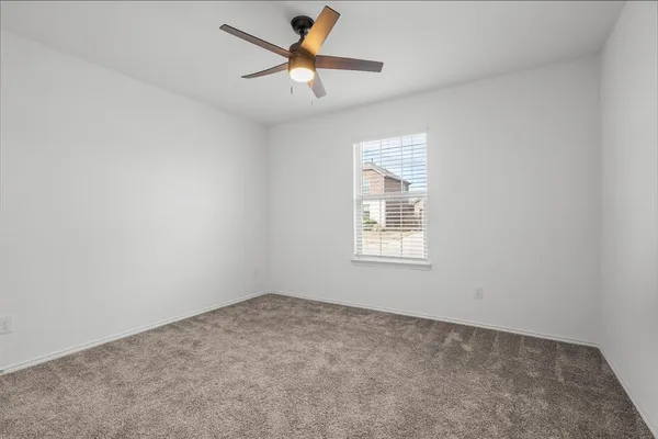 an empty room with a window and a fan