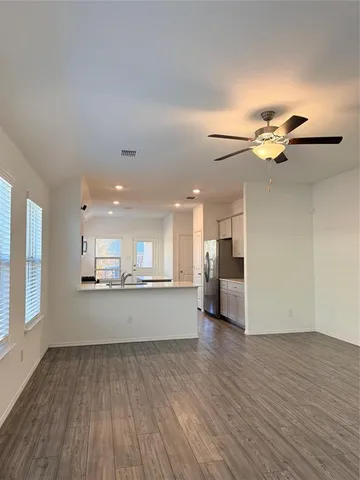 a view of a kitchen with wooden floor and a window