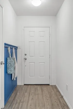 a view of an empty room with wooden floor and closet