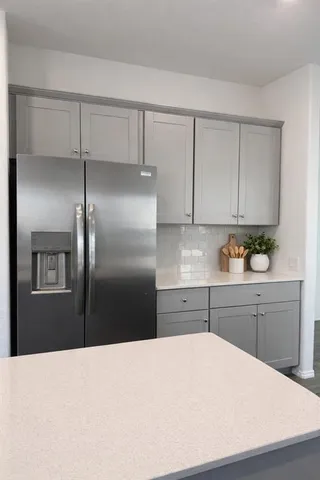 a kitchen with a refrigerator sink and cabinets