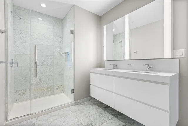 a bathroom with a shower sink and mirror
