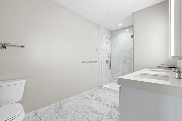 a bathroom with a sink a toilet and shower