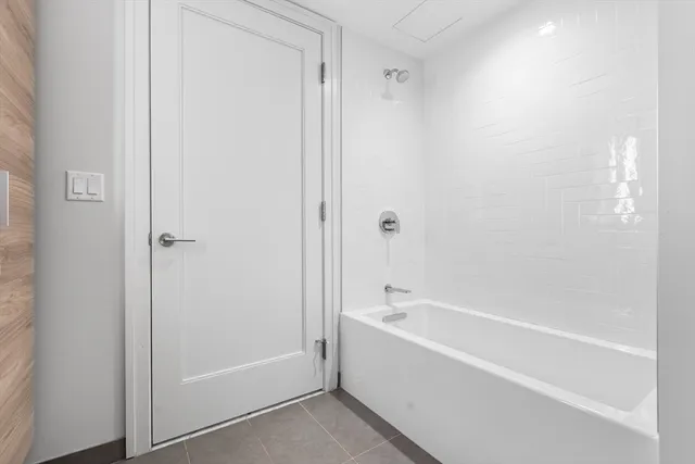 a white bath tub sitting next to a shower