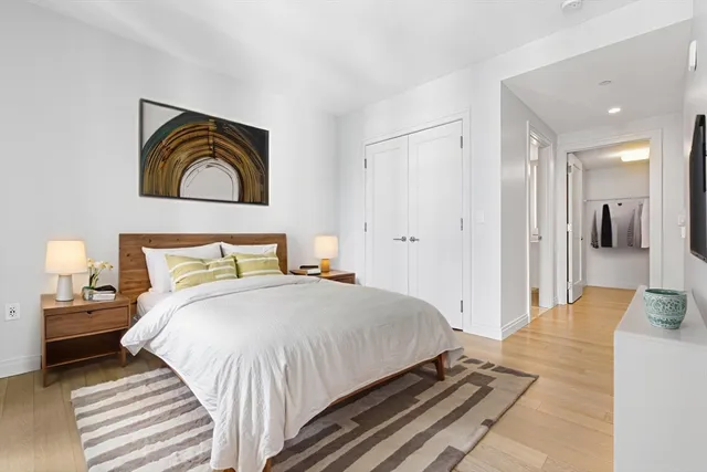 a bedroom with a bed and a painting on the wall