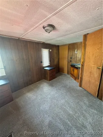 a view of an empty room with window and furniture