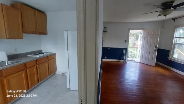 a view of a hallway with wooden floor and a cabinet