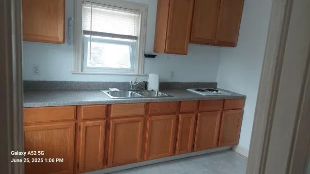 a kitchen with granite countertop a sink cabinets and a window
