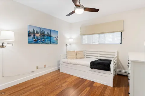 a bedroom with a bed and a wooden floor