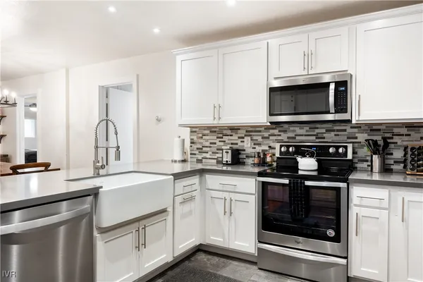a kitchen with white cabinets stainless steel appliances and sink
