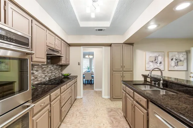 a kitchen with stainless steel appliances granite countertop a sink stove and refrigerator