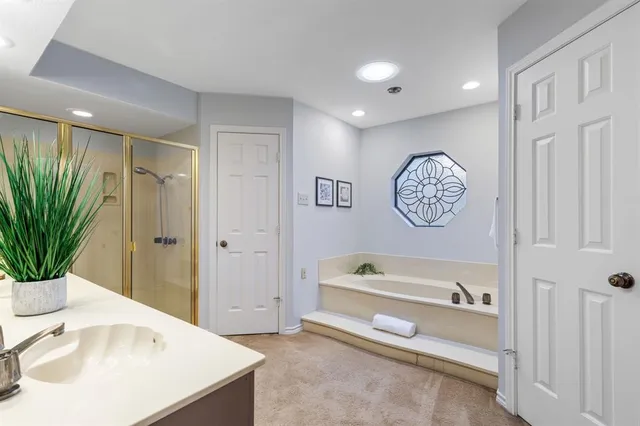 a spacious bathroom with a tub sink and mirror