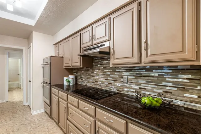 a kitchen with stainless steel appliances granite countertop a sink and a stove