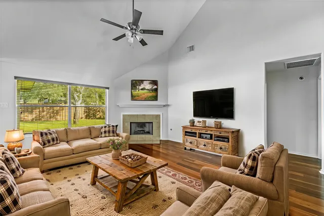 a living room with furniture a flat screen tv and a fireplace