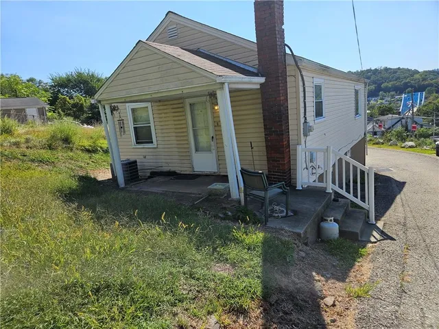 a view of a house with backyard and sitting area
