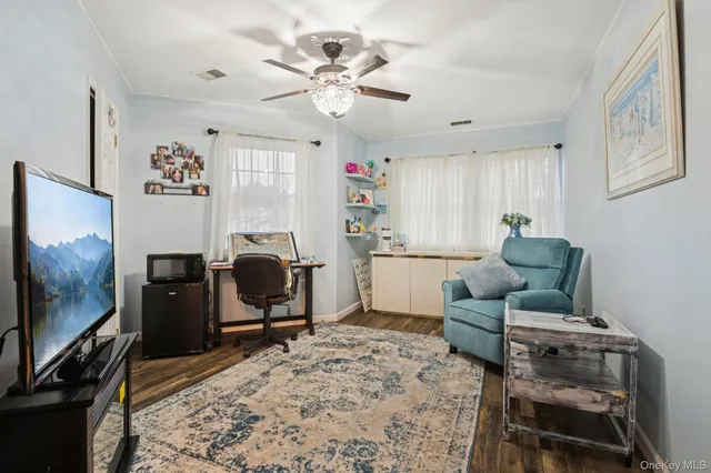 a living room with furniture workspace and a flat screen tv