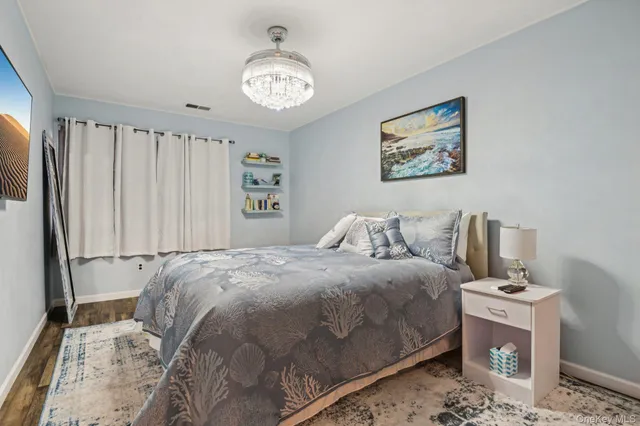 a bedroom with a large bed and a chandelier