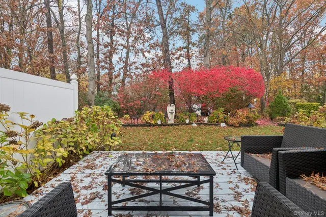 a view of a backyard with table and chairs plants and trees