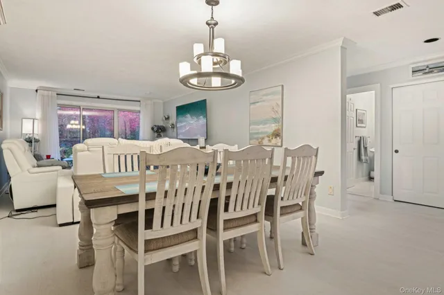 a view of a dining room with furniture and chandelier