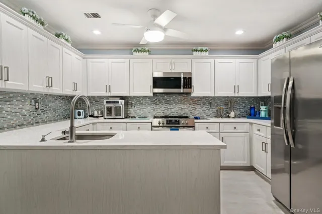a kitchen with kitchen island a sink stainless steel appliances and cabinets