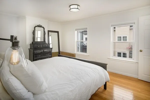a bedroom with a bed and wooden floor