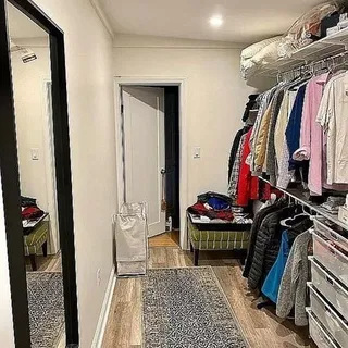 a view of walk in closet with clothes and shoes