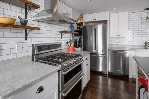 a kitchen with stainless steel appliances granite countertop a stove and a refrigerator