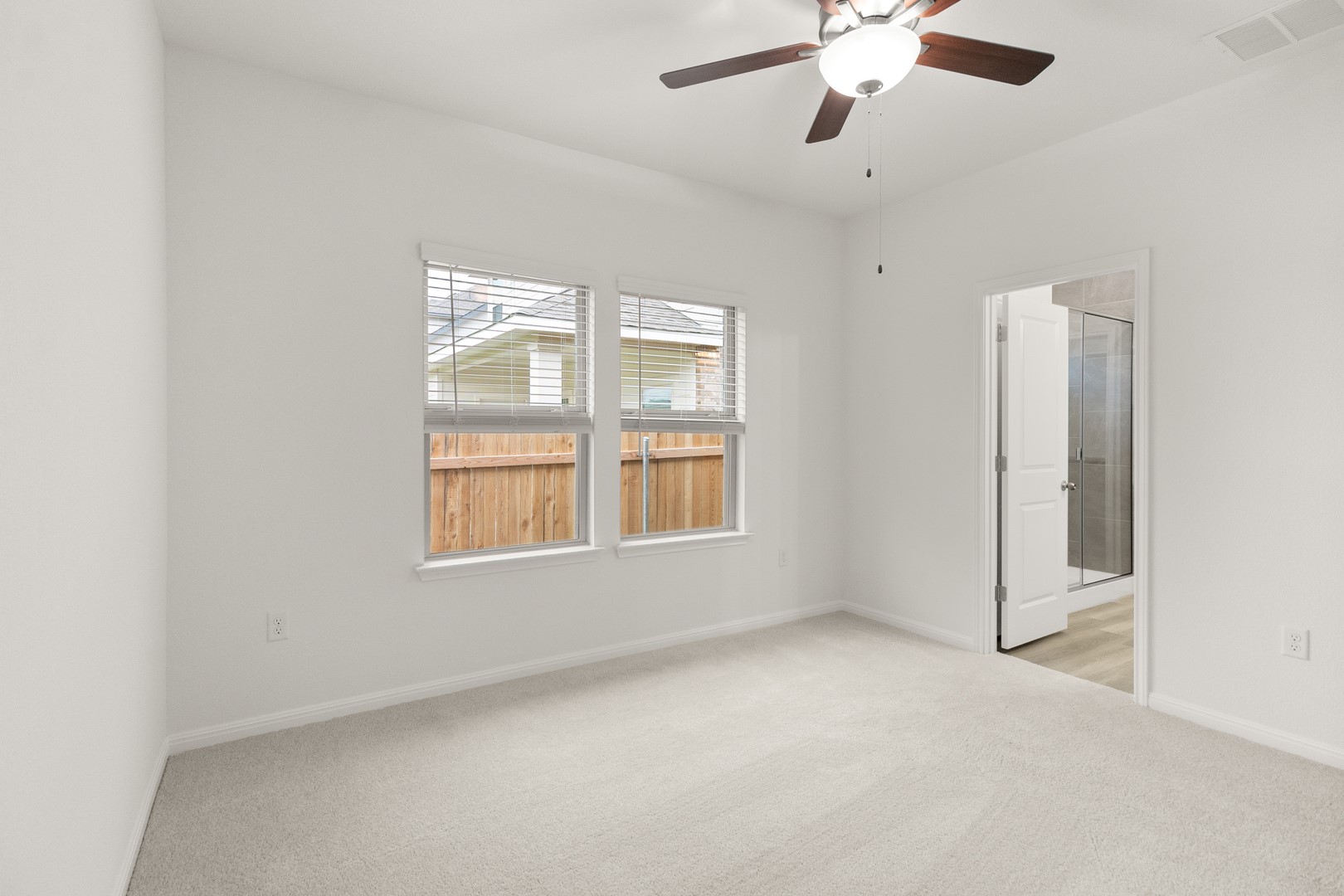 18605 Emu Lane Manor, TX 78653 - Photo 19 of 27 This room features light-colored carpeting, a ceiling fan with integrated lighting, and two windows with blinds